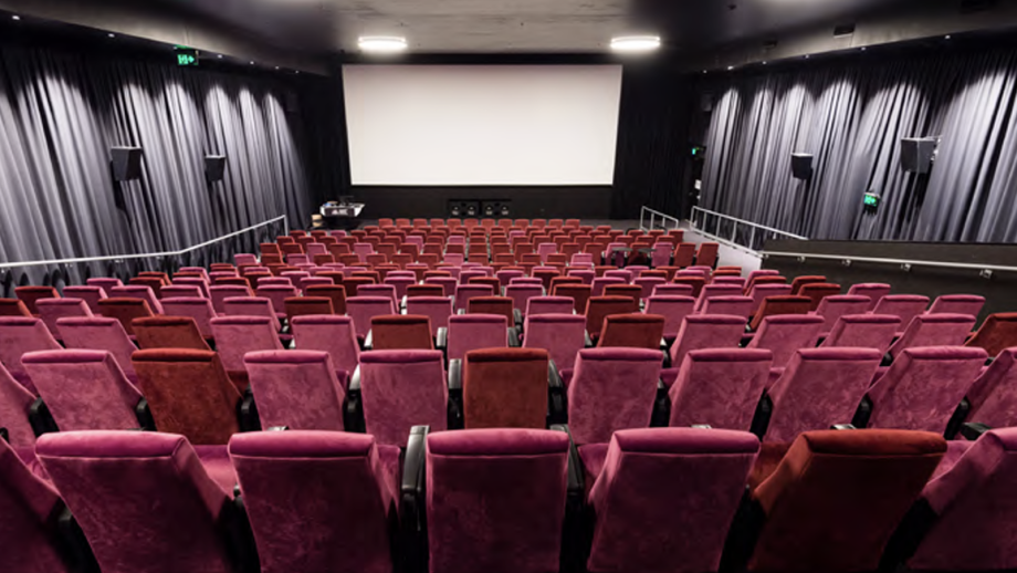 Seats in a cinema with the screen in the background